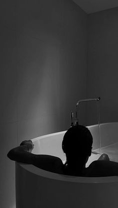 a person sitting in a bathtub with the light on