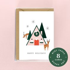 a christmas card with an image of a house and deer on it, surrounded by trees