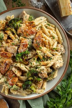 pasta with chicken, broccoli and parmesan cheese in a white bowl