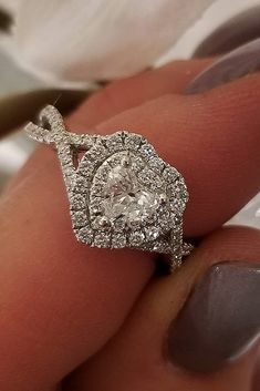 a close up of a person's hand with a diamond ring on their finger