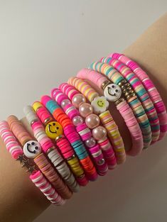 a woman's arm with several bracelets on top of it and an emoticive smiley face in the middle