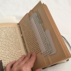 a person is holding an open book with a keyboard on it