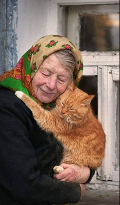 an old woman holding a cat in her arms