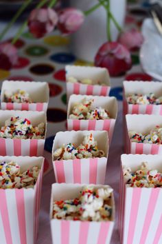 pink and white striped paper cups filled with popcorn