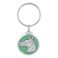 a keychain with a horse head on the front and green circle around it