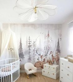 a baby's room with deer wallpaper and white furniture