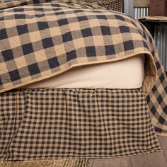 a black and white checkered bedspread on top of a wooden bed frame