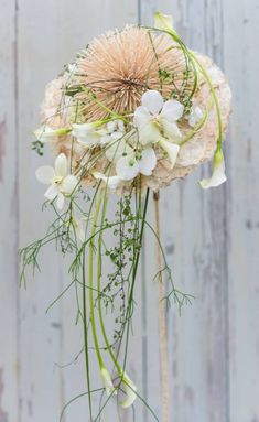 an arrangement of flowers and greenery in a vase