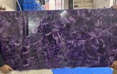 two men are holding a purple marble slab