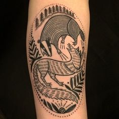 a black and white photo of a tattoo design on the right leg with an animal