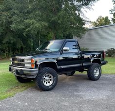 a black pickup truck parked in front of a house