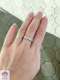 a woman's hand with a wedding ring on her left hand and a diamond in the middle