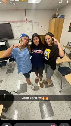 three girls posing for the camera in a classroom