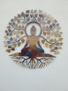 a metal wall hanging with a woman sitting in a yoga pose surrounded by tree branches