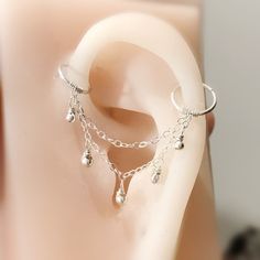 a close up view of a fake ear with chains and dangling beads on it's side