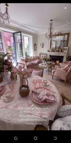 a dining room table with pink chairs and place settings on it, in front of a fireplace