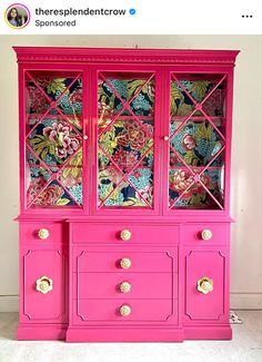 a pink china cabinet with flowers painted on it