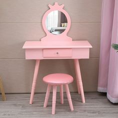 a pink vanity and stool with a mirror on the wall in a child's bedroom