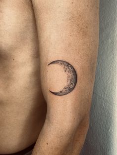 a man with a half moon tattoo on his arm