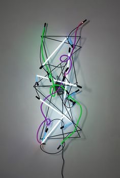 an abstract sculpture with neon lights and wires on the top, against a gray background