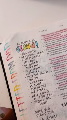 an open bible with colorful lettering on it