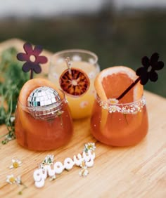 two oranges are sitting on a cutting board next to some flowers and a disco ball