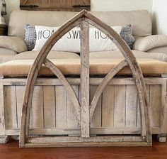 a wooden bench sitting on top of a hard wood floor next to a white couch