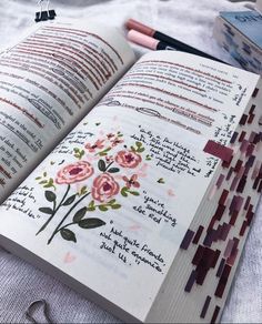 an open book with flowers on it and some other items next to it that include scissors