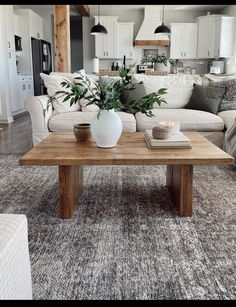 a living room filled with furniture and a wooden coffee table in front of a white couch