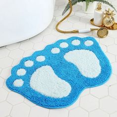 two blue and white bathroom rugs with paw prints on them next to a bath tub