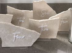 four pieces of stone with the words four and six written on them next to a candle