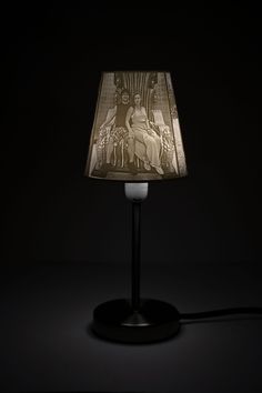 a lamp that is lit up in the dark with an image of jesus on it