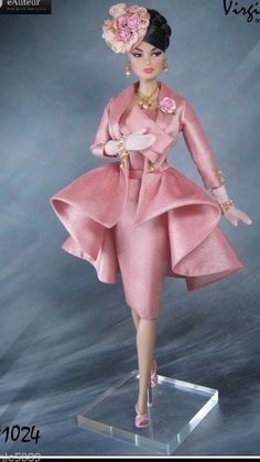 a barbie doll wearing a pink dress and hat