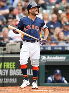 a baseball player holding a bat on top of a field in front of a crowd