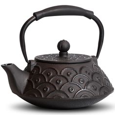 an iron tea pot with a handle on the top and circular designs painted on it