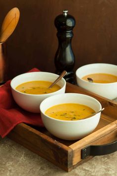 two bowls of soup are on a tray