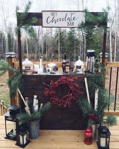 a hot chocolate bar decorated with greenery and christmas wreaths