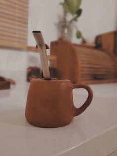 a coffee cup with a spoon sticking out of it sitting on top of a counter