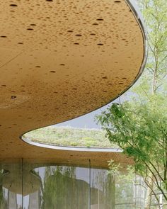 an artisticly designed building with trees in the foreground