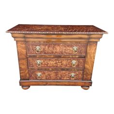 a wooden chest with three drawers on one side and two brass knobs on the other