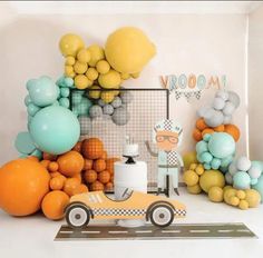 an orange car is parked in front of balloons