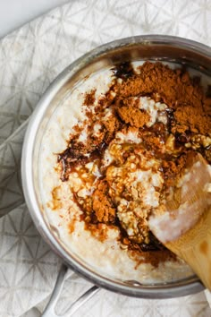 the ingredients are being mixed together in a bowl with a wooden spatula on top