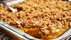 a casserole dish filled with peaches and crumbled toppings on top