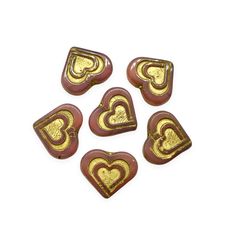 six heart shaped glass beads with gold foiling on the sides and two hearts in the middle