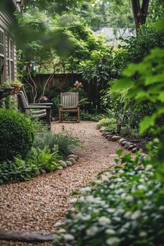 a garden with gravel path and chairs next to the house, surrounded by greenery