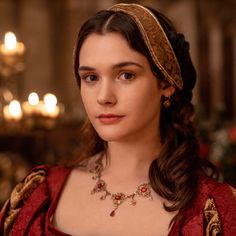 a woman wearing a red dress with a gold headband and necklace on her neck