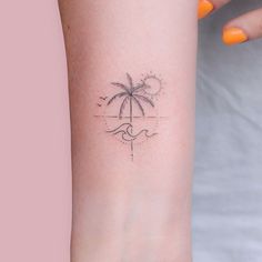 a woman's arm with a small palm tree tattoo on the left inner arm