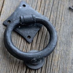 an old black door handle on a wooden surface