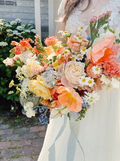 a woman holding a bouquet of flowers in her hands