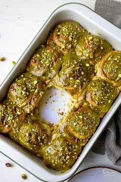 a casserole dish filled with pesto covered rolls